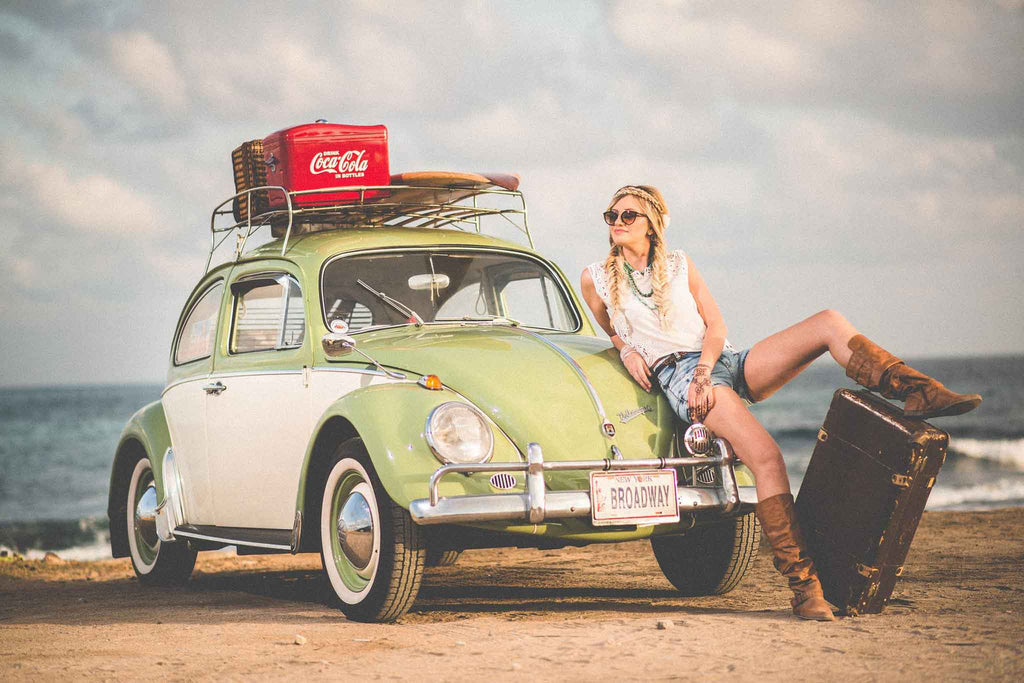 vrouw en auto op het strand met bagage
